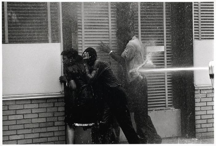 firefighters aiming high pressure water hoses at civil rights demonstrators